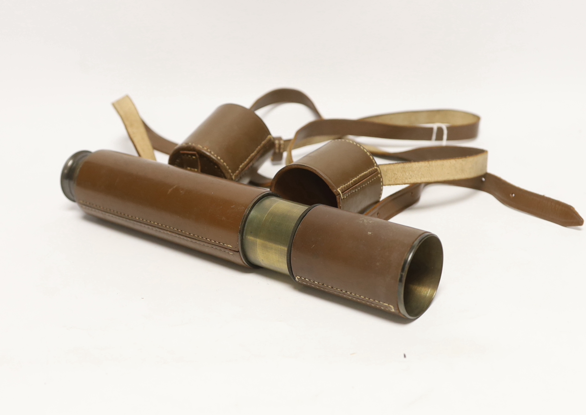 A leather cased three-drawer telescope with carrying strap, 27cm closed, 69cm fully opened